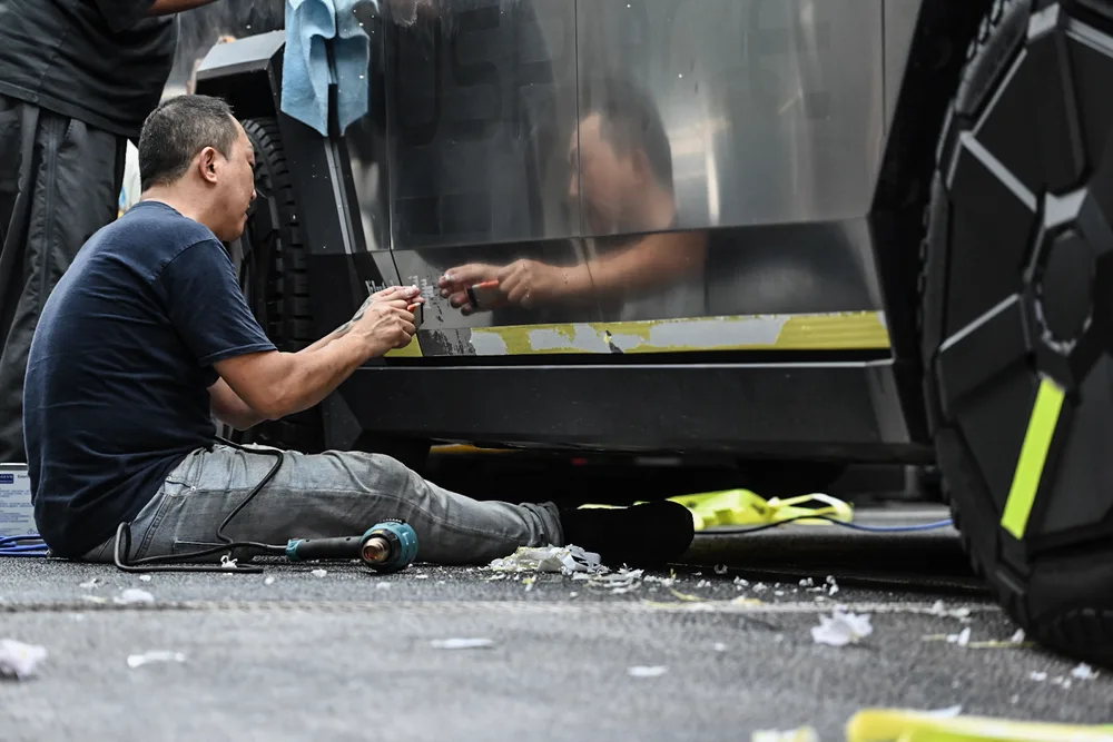 技師坐在地面處理車側下緣,地上散落撕下的貼膜碎片