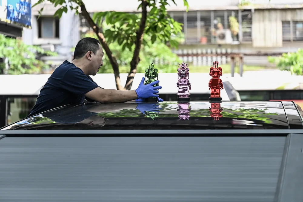技師以布巾擦拭車斗上蓋,清除作業後的殘留水痕