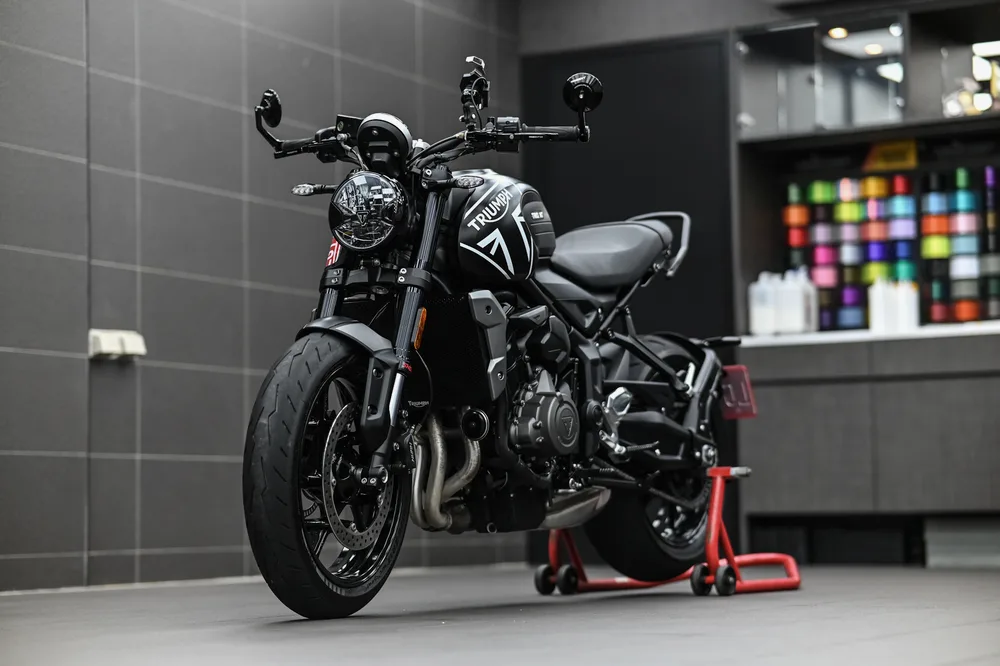 Triumph Trident 重機鍍膜完工後停放於施工區，油箱與前叉呈現均勻黑色光澤，誠美車體美容